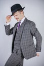 Stylish young man in plaid retro business suit and vintage top hat on white solid background in Studio Royalty Free Stock Photo