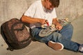 Stylish young man repairing his skateboard in the skate park. Extreme sport concept Royalty Free Stock Photo