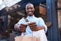 Stylish young man standing outside holding up shopping bags Royalty Free Stock Photo