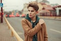 Stylish young man in a trendy vintage coat with hoodie