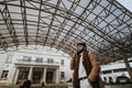 Fashionable man making a phone call under modern canopy structure outdoors Royalty Free Stock Photo