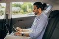 Stylish young middle-eastern guy independent contractor working in car