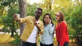 Stylish young people man and women are taking selfie wearing sunglasses posing and smiling holding smartphone during Royalty Free Stock Photo