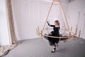 Stylish young rich woman in an evening dress. lobby of the hotel. Suite. Giant huge chandelier lamp. Royalty Free Stock Photo