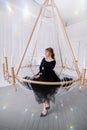 Stylish young rich woman in an evening dress. lobby of the hotel. Suite. Giant huge chandelier lamp. Royalty Free Stock Photo