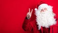 Stylish young Santa in all red shows a hello sign Royalty Free Stock Photo