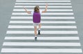 Stylish young teen girl walking with backpack. Active child. Kid runs across the crosswalk. A school child jumps down the street. Royalty Free Stock Photo