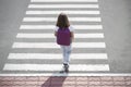 Stylish young teen girl walking with backpack. Active child. Kid runs across the crosswalk. Way forward. Direction to success. Royalty Free Stock Photo