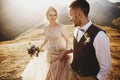 Stylish young wedding couple has fun posing in beautiful Georgian mountains