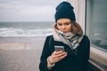 Stylish young woman in coat, beanie hat and scarf