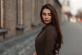 Stylish young woman in a fashion jacket in the street near