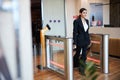 Stylish young woman passing electronic turnstile at airport