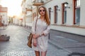 Stylish young woman in sunglasses walking in the city at sunset Royalty Free Stock Photo