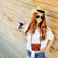 Stylish young woman with vintage camera. Outdoor fashion portrait - copyspace