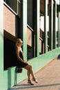 Stylish young woman walking around the city resting sitting on the parking wall Royalty Free Stock Photo