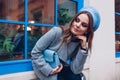 Stylish young woman wearing coat blue beret holding small purse outdoors. Spring fashionable female accessories Royalty Free Stock Photo