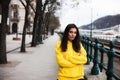 Stylish young woman in yellow hoody posing in the city streets. Royalty Free Stock Photo