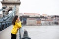 Stylish young woman in yellow hoody posing in the city streets. Royalty Free Stock Photo