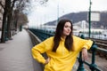 Stylish young woman in yellow hoody posing in the city streets. Royalty Free Stock Photo