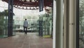 A stylishly dressed man walks down a glass corridor in a modern office. Shooting from the back of the hands. Confident Royalty Free Stock Photo