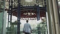 A stylishly dressed man walks down a glass corridor in a modern office. Shooting from the back of the hands. Confident Royalty Free Stock Photo