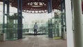 A stylishly dressed man walks down a glass corridor in a modern office. Shooting from the back of the hands. Confident Royalty Free Stock Photo