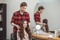 Stylist barber styling long hair for beautiful asian young woman in beauty salon, working moment Royalty Free Stock Photo