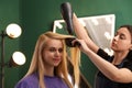 Stylist blow drying woman`s hair Royalty Free Stock Photo