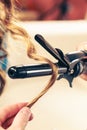 Stylist curling hair for young woman. Royalty Free Stock Photo