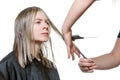 Stylist cutting hair of young blonde woman. Royalty Free Stock Photo