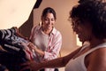 Stylist Discussing Wardrobe With Female Photographer On Fashion Shoot In Studio Royalty Free Stock Photo