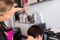 Stylist drying woman hair in hairdresser salon. Royalty Free Stock Photo