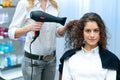 Stylist drying woman hair in salon Royalty Free Stock Photo