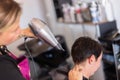 Stylist drying woman hair in hairdresser salon. Royalty Free Stock Photo