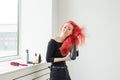 Stylist, fashion, hairdresser, people concept - woman drying her colored hair Royalty Free Stock Photo