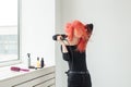 Stylist, fashion, hairdresser, people concept - woman drying her colored hair Royalty Free Stock Photo