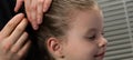 Stylist hairdresser. creates a hairstyle for the evening, a little girl, stabs hair with a hairpin. Royalty Free Stock Photo