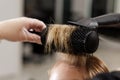 Close up blowout with round brush and blowdryer creating root volume in a salon Royalty Free Stock Photo