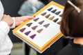 Stylist`s hand holding palette of hair dye samples. Royalty Free Stock Photo