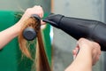 Stylist`s hands drying long brown hair