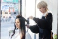 Stylist Using Curling Iron with Caucasian Customer for Hair Curls Royalty Free Stock Photo