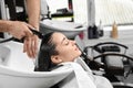 Stylist washing client`s hair at sink in beauty Royalty Free Stock Photo