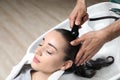 Stylist washing client`s hair at sink in beauty salon