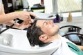 Stylist washing client`s hair at sink in salon Royalty Free Stock Photo