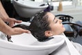 Stylist washing client`s hair at sink in salon Royalty Free Stock Photo