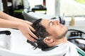 Stylist washing client`s hair at sink in salon Royalty Free Stock Photo