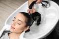 Stylist washing client`s hair at sink