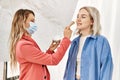 Stylist woman applying make up to beautiful caucasian model at photo shoot backstage, getting ready for professional photoshoot