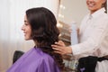 Stylist working with client in salon, making hairstyle