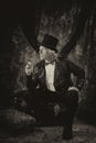 Antiqued steampunk portrait of man sitting on trunk Royalty Free Stock Photo